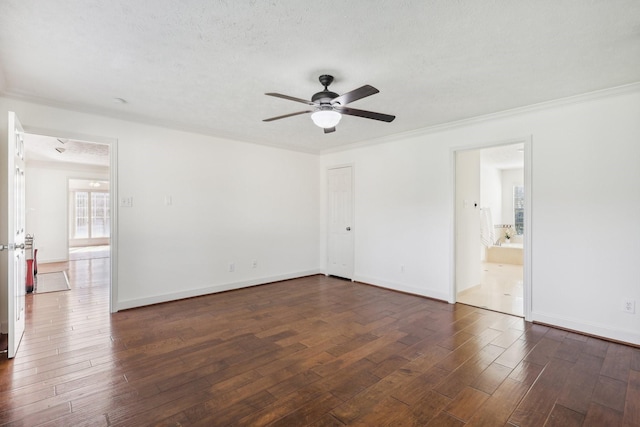 spare room with a textured ceiling, dark hardwood / wood-style flooring, ceiling fan, and ornamental molding