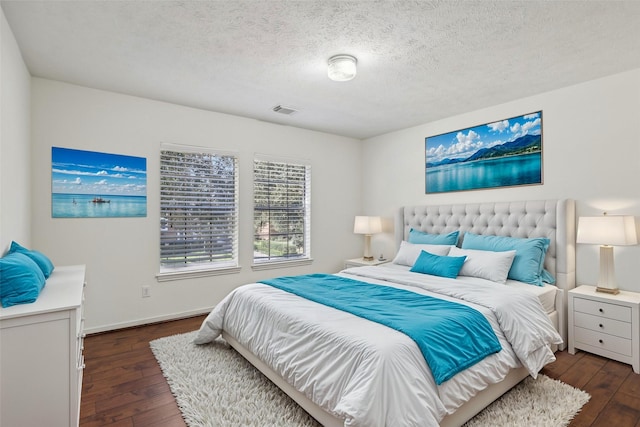 bedroom with dark wood-type flooring and a textured ceiling