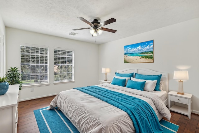 bedroom featuring ceiling fan, dark hardwood / wood-style flooring, and a textured ceiling