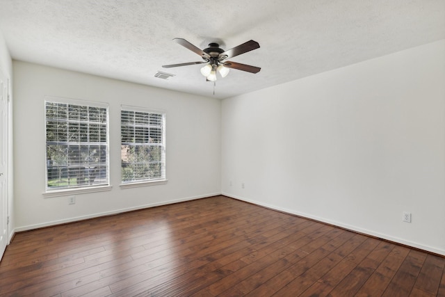 unfurnished room with ceiling fan, dark wood-type flooring, and a textured ceiling