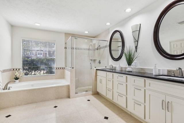 bathroom with tile patterned flooring, vanity, a textured ceiling, and independent shower and bath