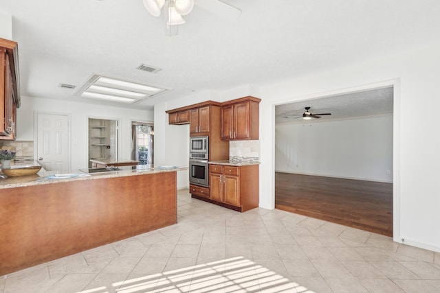 kitchen with kitchen peninsula, appliances with stainless steel finishes, light wood-type flooring, backsplash, and ceiling fan