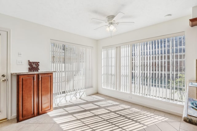 unfurnished sunroom with ceiling fan