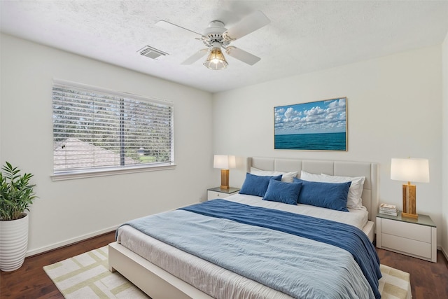 bedroom featuring a textured ceiling, ceiling fan, and dark wood-type flooring