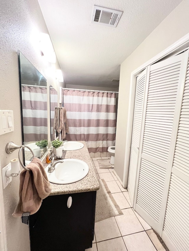 bathroom with vanity, a textured ceiling, tile patterned floors, a shower with curtain, and toilet