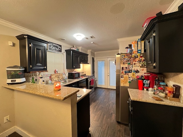 kitchen with kitchen peninsula, stainless steel appliances, a textured ceiling, ornamental molding, and dark hardwood / wood-style floors