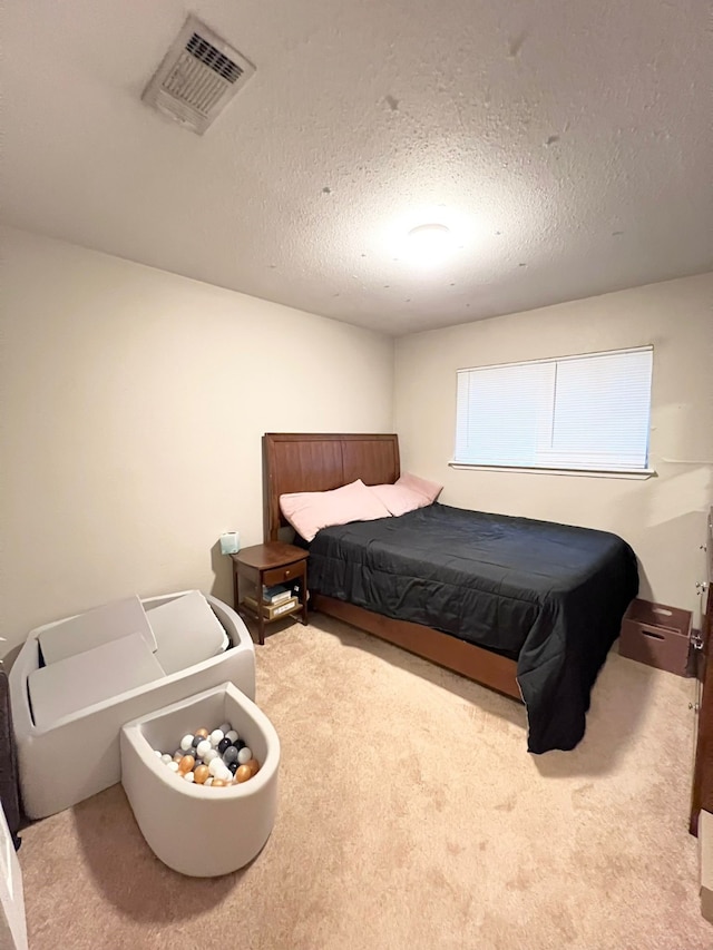 bedroom featuring a textured ceiling and carpet floors