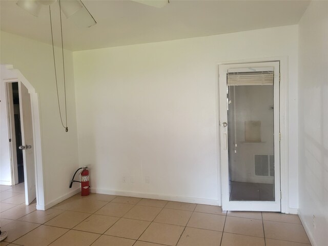 empty room featuring light tile patterned floors and ceiling fan