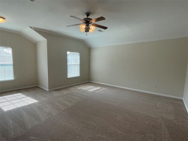 empty room with vaulted ceiling, ceiling fan, plenty of natural light, and crown molding