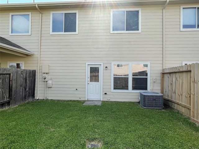 back of property with a yard and central air condition unit