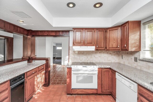 kitchen featuring white appliances, a raised ceiling, and decorative backsplash