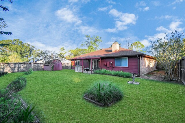 rear view of house with a storage shed and a lawn