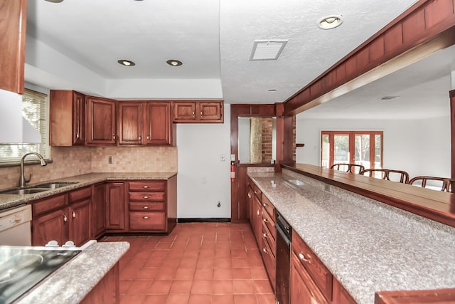 kitchen with black electric cooktop, sink, light stone counters, white dishwasher, and decorative backsplash