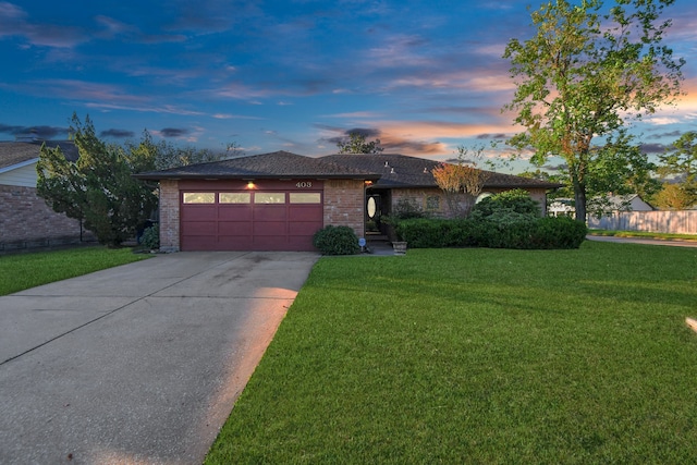 view of front of house featuring a garage and a lawn