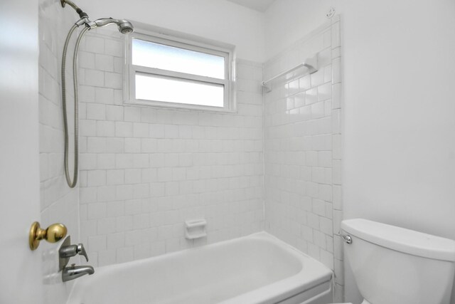 bathroom featuring toilet and tiled shower / bath combo