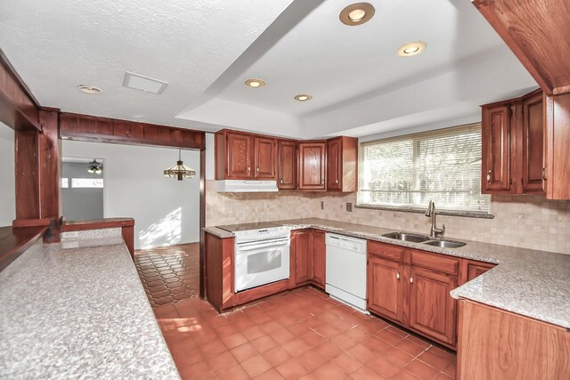 kitchen with white appliances, hanging light fixtures, decorative backsplash, sink, and a tray ceiling