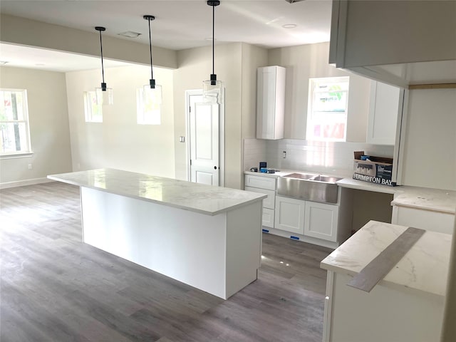 kitchen featuring a center island, white cabinets, backsplash, decorative light fixtures, and dark hardwood / wood-style flooring