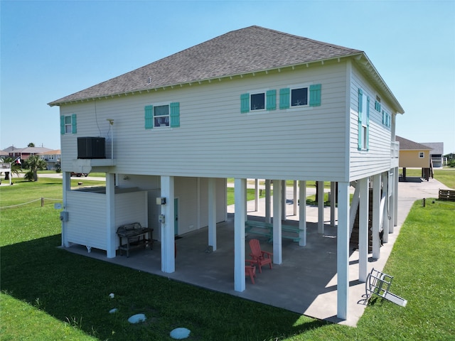 back of house featuring a lawn, cooling unit, and a patio