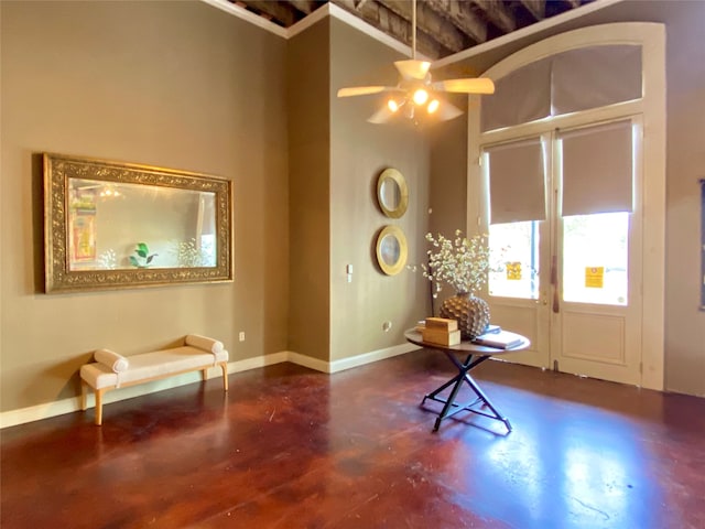 entryway with a towering ceiling and ceiling fan