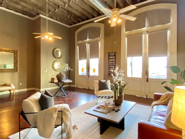 living room with a high ceiling, dark wood-type flooring, ceiling fan, and french doors