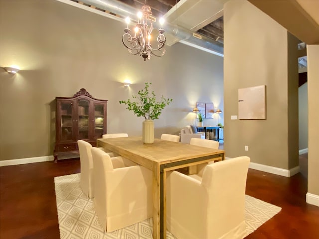 dining space featuring hardwood / wood-style floors, a chandelier, and a high ceiling