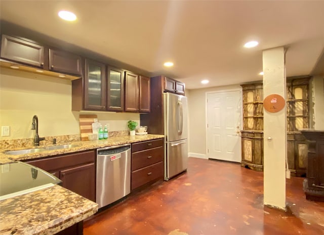 kitchen featuring appliances with stainless steel finishes, sink, and light stone counters