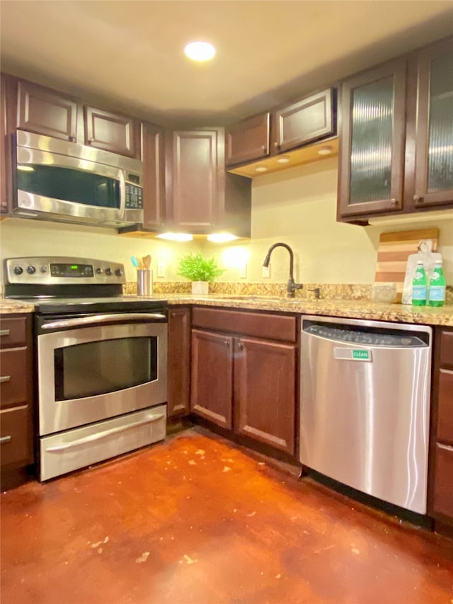 kitchen featuring light stone counters, appliances with stainless steel finishes, and sink