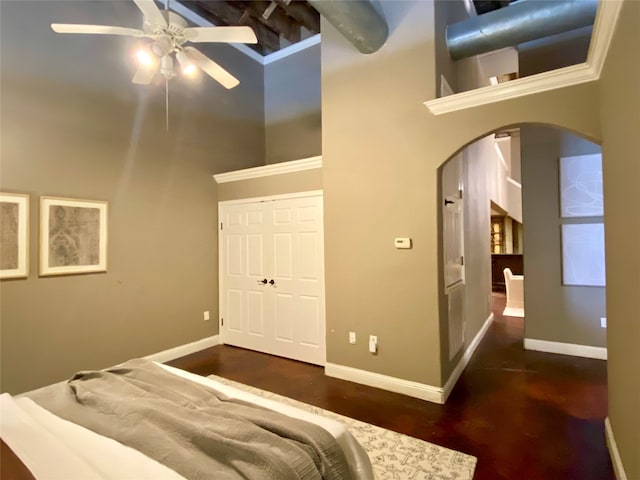 bedroom featuring a closet, a towering ceiling, beam ceiling, and ceiling fan