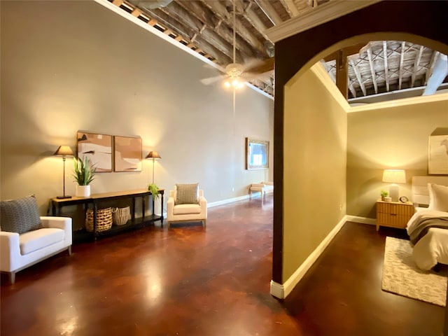 sitting room with a towering ceiling and ceiling fan