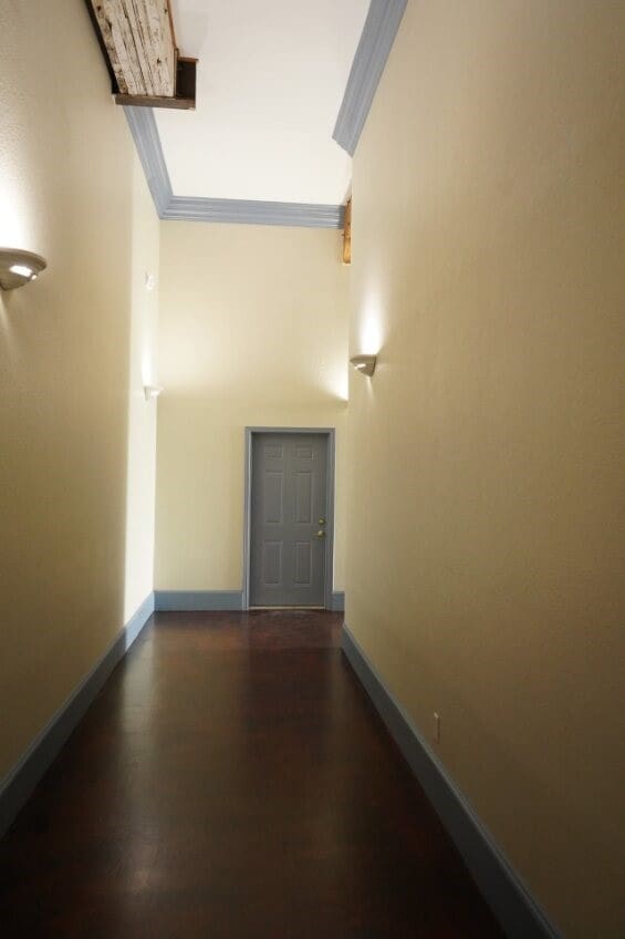 corridor featuring ornamental molding and dark hardwood / wood-style flooring