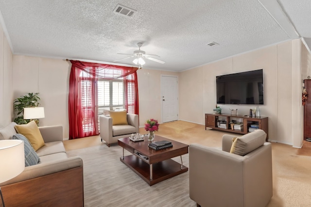 living room with ceiling fan, light colored carpet, crown molding, and a textured ceiling