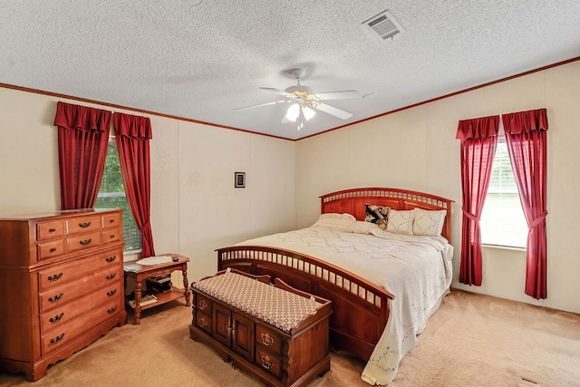 bedroom with ceiling fan, a textured ceiling, light carpet, and crown molding