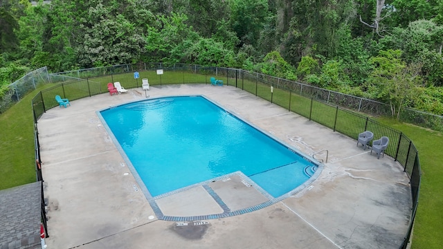 view of pool featuring a lawn