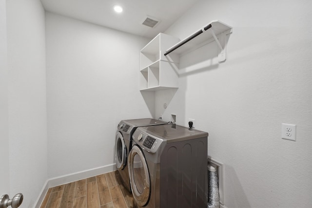 washroom featuring hardwood / wood-style flooring and washing machine and dryer