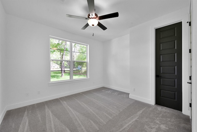 carpeted spare room featuring ceiling fan