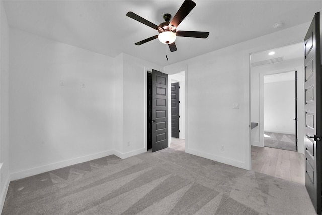 unfurnished bedroom featuring ceiling fan, a closet, and light colored carpet