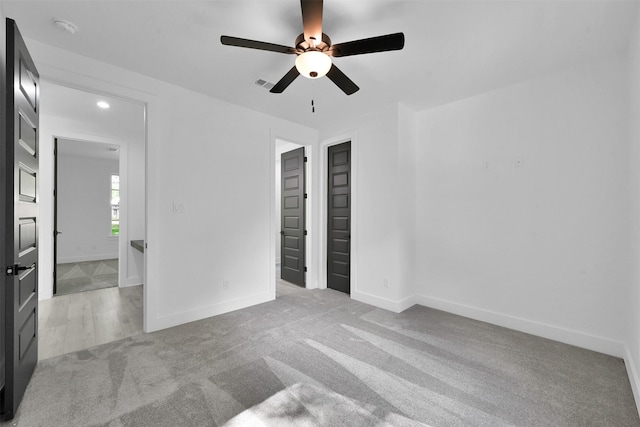 carpeted spare room featuring ceiling fan