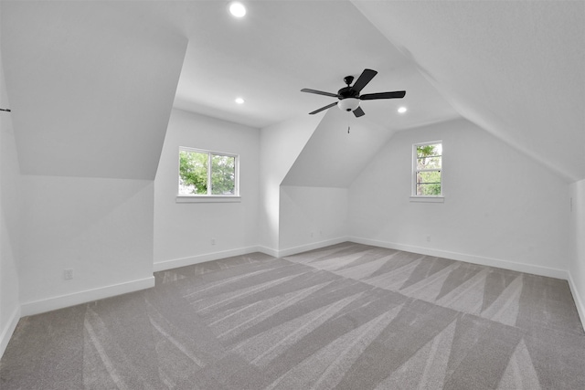 additional living space featuring ceiling fan, light colored carpet, and a healthy amount of sunlight