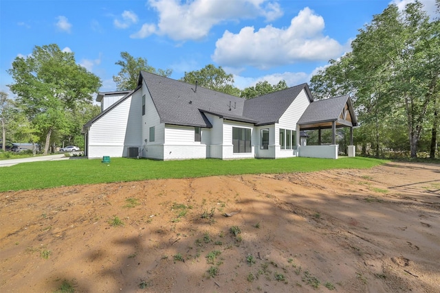 back of house featuring a yard and central AC unit