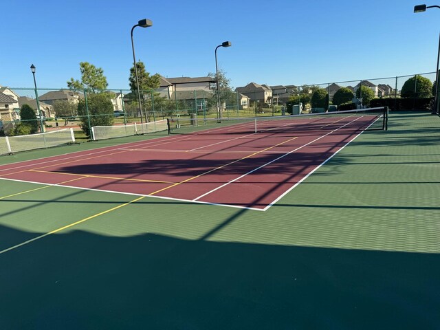 view of tennis court with basketball hoop