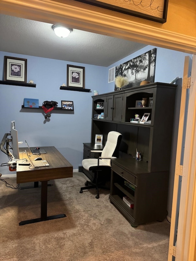 carpeted office featuring a textured ceiling