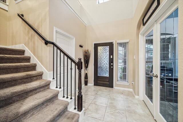 foyer featuring a towering ceiling and french doors