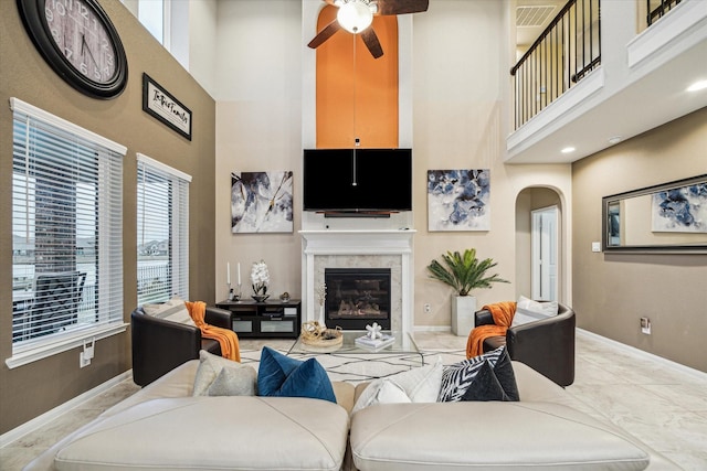 living room with ceiling fan and a high ceiling