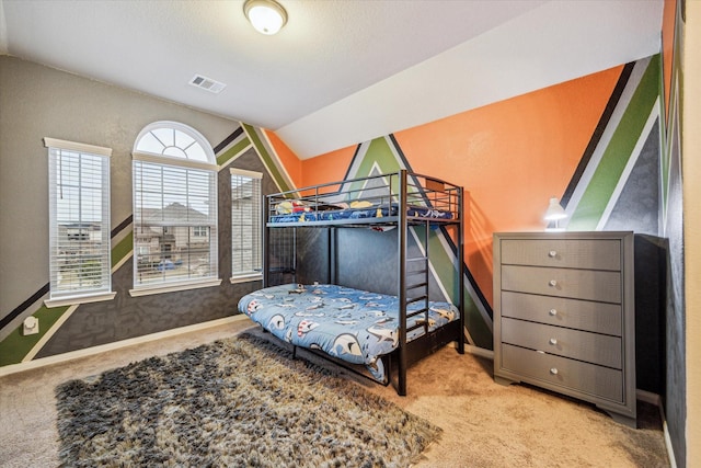 bedroom with vaulted ceiling and light carpet