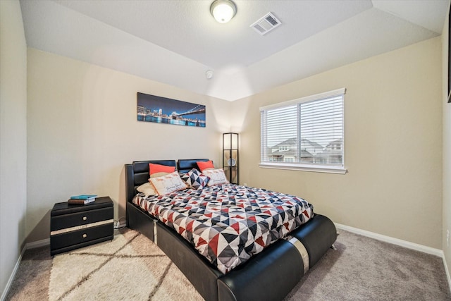 bedroom featuring a tray ceiling and light colored carpet