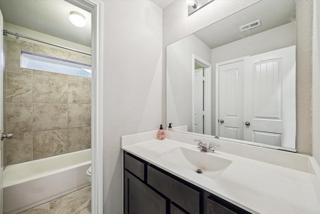 full bathroom with vanity, toilet, and tiled shower / bath combo