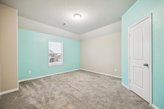 carpeted empty room with vaulted ceiling and a textured ceiling