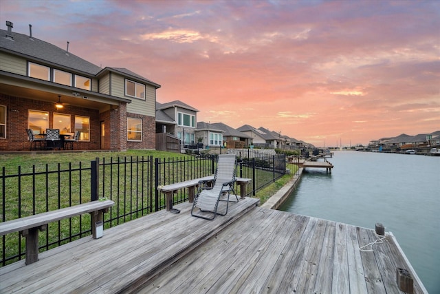 dock area featuring a water view and a lawn