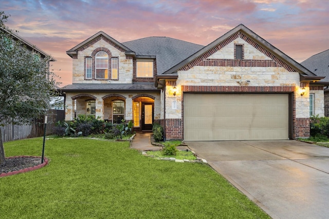 view of front of house featuring a garage, a yard, and covered porch