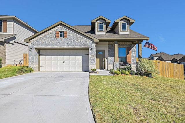 view of front of property featuring a garage, a front lawn, and covered porch